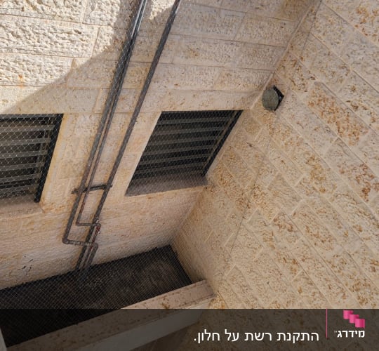 רשת מתכת על קיר למניעת כניסת יונים